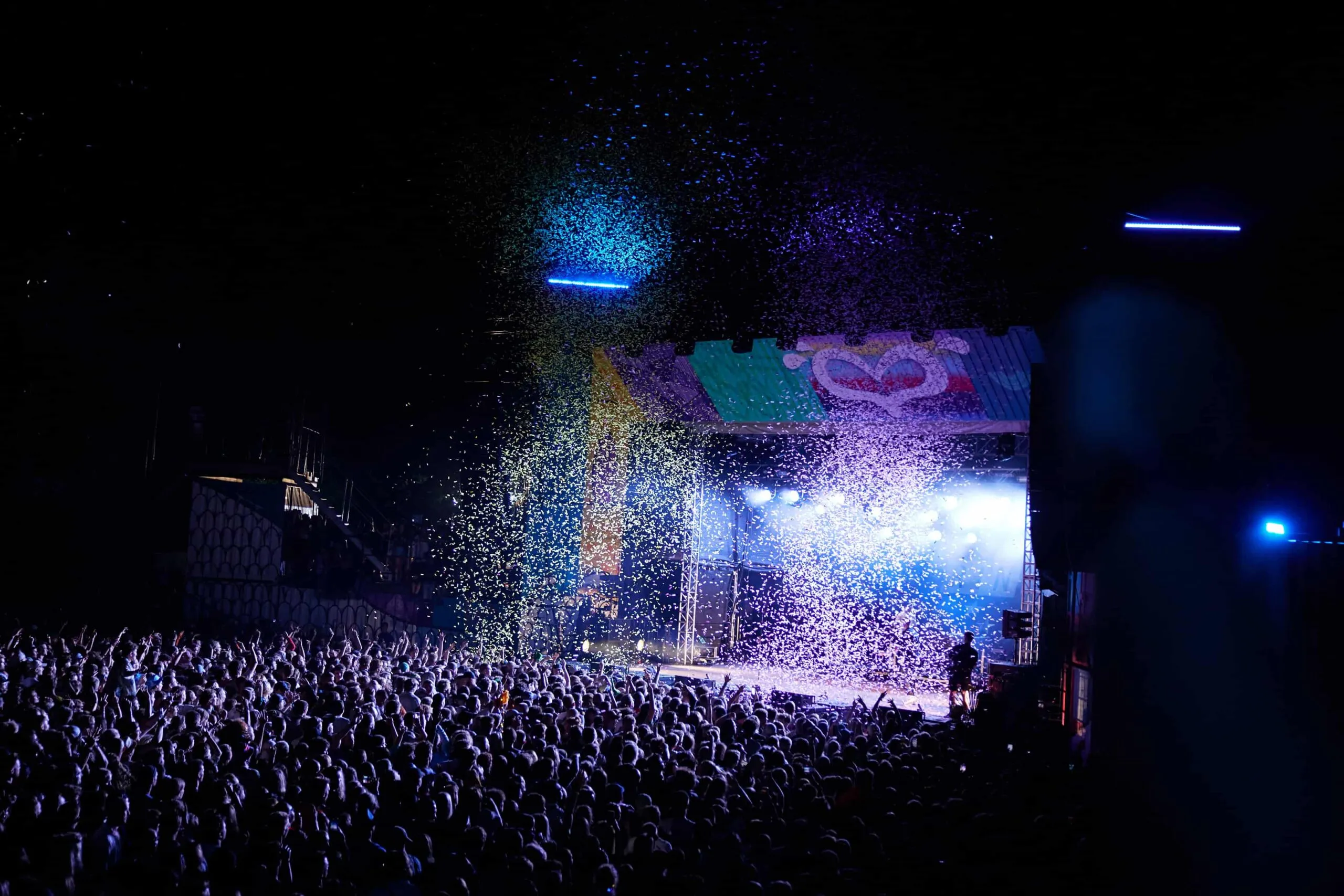 Festivalbühne mit Publikum und Konfetti bei Nacht
